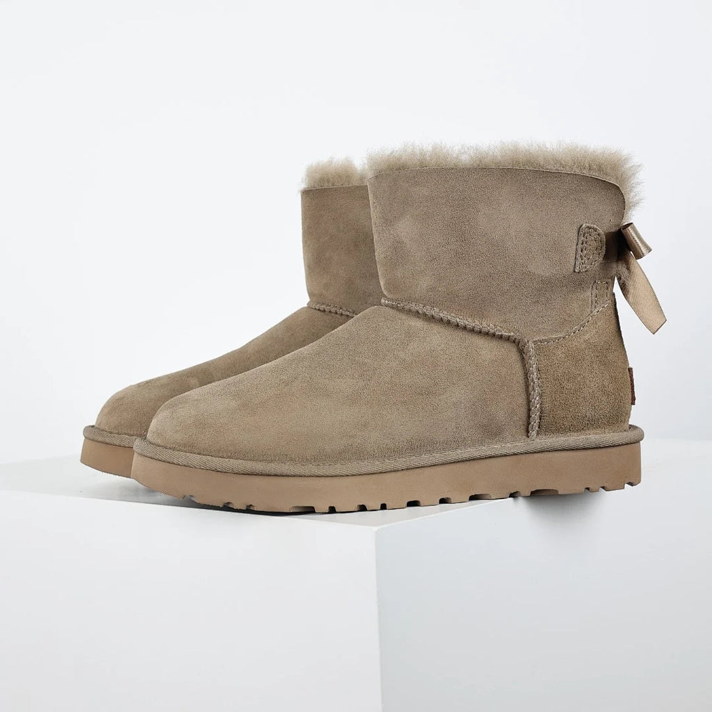 UGG Bailey Bow Mini Ankle Boot – Sand | Shearling-Lined Women's Winter Boot