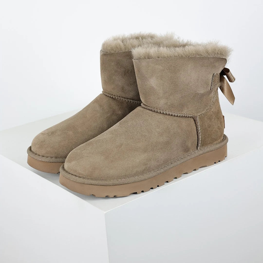 UGG Bailey Bow Mini Ankle Boot – Sand | Shearling-Lined Women's Winter Boot