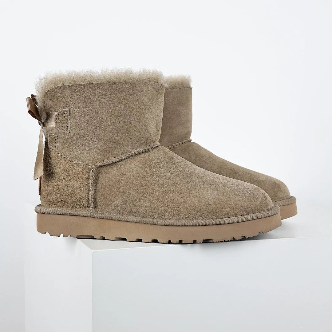UGG Bailey Bow Mini Ankle Boot – Sand | Shearling-Lined Women's Winter Boot