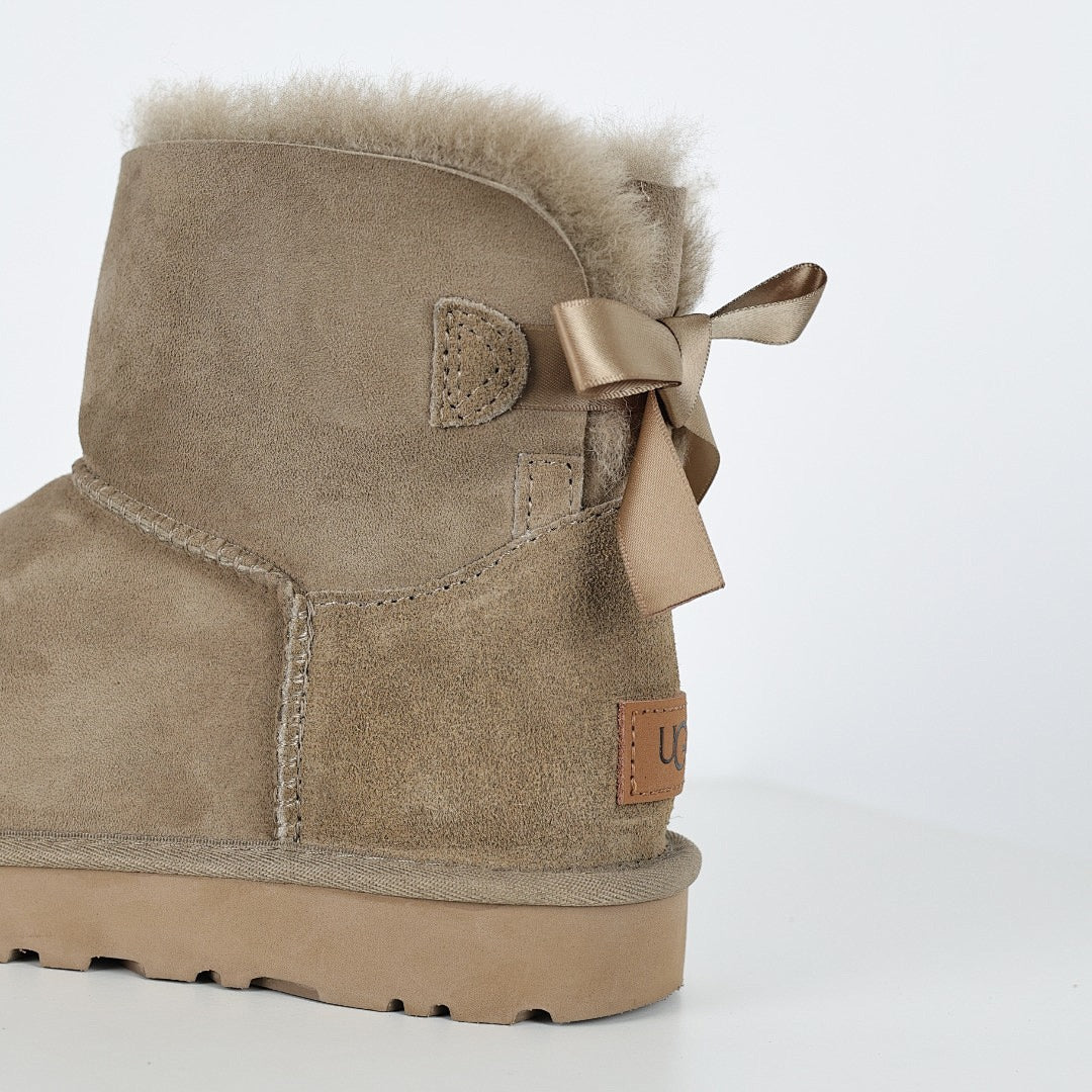UGG Bailey Bow Mini Ankle Boot – Sand | Shearling-Lined Women's Winter Boot